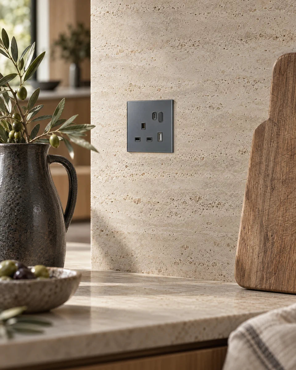 A grey glass smart socket set into a travertine kitchen splashback