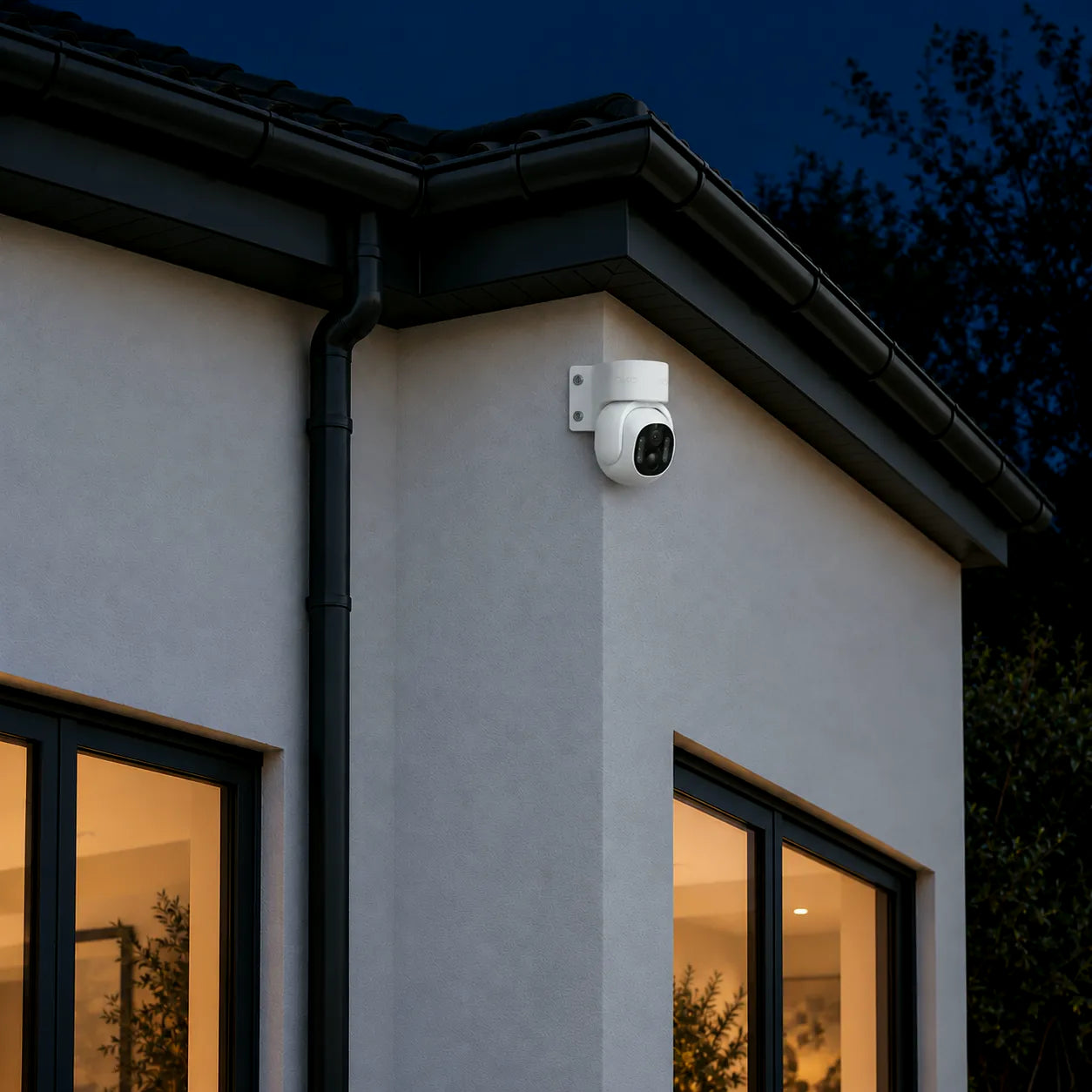 Wired security camera Pro 8MP fitted on the outside corner of a house under the eaves at night, free to turn toward either side